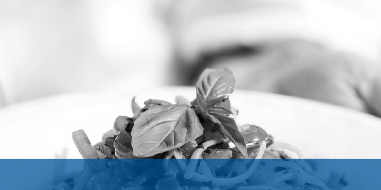Hands holding a plate of pasta